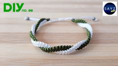 a white and green string bracelet sitting on top of a wooden table