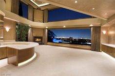 a large bathroom with an oval tub in front of a huge window overlooking the city