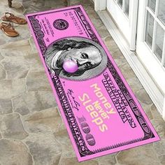 a large pink money bill with a woman's face on it is laying next to a pair of shoes