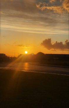 the sun is setting over an airport runway