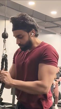 a man is working out in the gym with his hands on an exercise rope and looking down