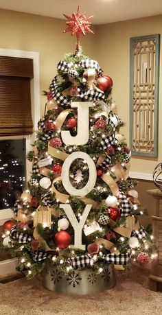 a decorated christmas tree with the word joy spelled out on it's top and decorations