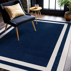 a blue and white rug in a living room next to a window with potted plants