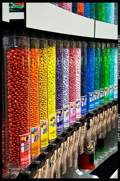 there are many different colors of candy in the vending machine