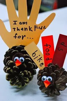 two pine cones are sitting next to each other with handprints on them that say i am thanksgiving for kids