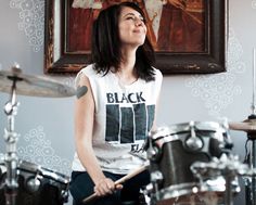 a woman sitting on top of a drum set