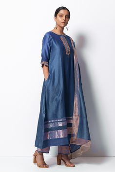 Blue handwoven kurta with zardozi floral motif embroidered placket and sleeves. Paired with cotton silk pant and stole with tassels. Comes with slip.
Component: 4
Pattern: Embroidered
Type Of Work: Floral Motifs
Neckline: Round
Sleeve Type: Elbow
Fabric: Kurta: Handwoven Chanderi Silk; Stole: Chanderi; Pant: Cotton Silk
Color: Blue
Other Details: 
Front concealed placket
Side slit kurta
Kasab thread zari tassels
Side pocketed kurta
Occasion: Puja - Aza Fashions Silk Kurta Set, Silk Stoles, Silk Pant, Blue Kurta, Silk Kurta, Silk Pants, Cotton Set, Pants Design, Floral Motifs