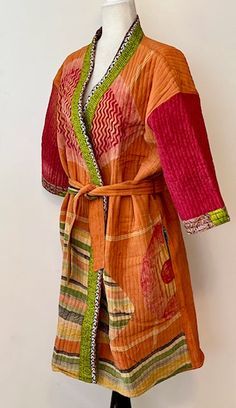 Mid Length Designer Kimono Jacket Is New and Unusual. Beautiful Transition Colors. Designer jacket made with kantha quilt fabric which is fresh and new. This kantha fabric is hand stitched. The front side is vintage crepe silk saree fabric. Beautiful color blend of orange, marigold, cerise, and rust. Inner side is pure cotton fabric. A sensational look is created with a beautiful geometric and stripe print. Hidden side pockets at each side seam. There is a natural cotton filling inside of these Orange Patchwork Outerwear For Spring, Traditional Orange Long Sleeve Kimono, Traditional Orange Long Sleeve Outerwear, Traditional Long Sleeve Orange Outerwear, Designer Kimono, Orange Marigold, Sari Quilt, Crepe Silk Sarees, Kantha Fabric