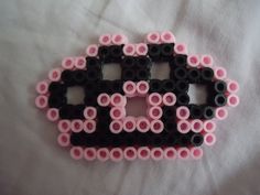 a black and pink car made out of legos on a white sheet with the word love spelled in it