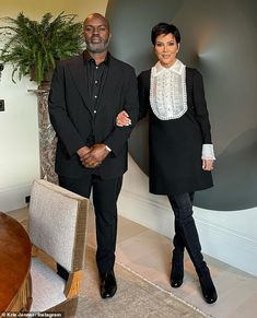 a man and woman standing next to each other in front of a table with chairs