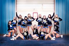 a group of cheerleaders posing in front of a garage door