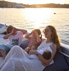 a woman and two children are sitting on a boat