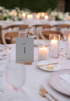 the table is set with candles and place cards