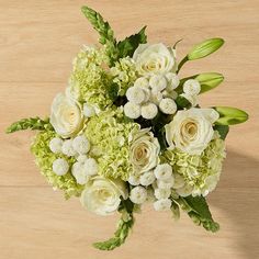 a bouquet of white flowers sitting on top of a wooden table