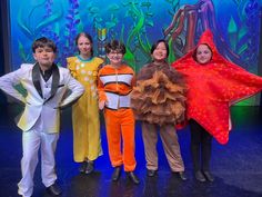 children in costumes posing for a photo on stage