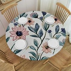 the table is set with four plates and two cups on it, which are decorated with flowers