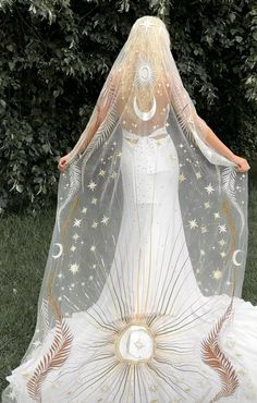 a woman in a white dress with a veil on her head and stars around her body