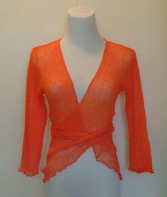 This delicate Knitted Bolero Jacket in stunning Orange color is really a versatile piece.  You can wear it on top of just about anything.  It can pack away very neatly too as it is fine and will not take up much space in your handbag.  Perfect for days out when you feel you may need to cover up a little.    It is perfect for so many occasions. Whether you are going to a beach party or simply going shopping, you will look stylish without effort. It will match any style of outfit as it is both casual and elegant.   One size fits ALL from size S-L  Here is another bolero jacket cardigan in a deeper blue which you may also like http://www.etsy.com/listing/89091515/knitted-bolero-cardigan   All my fashion items are designed and created by me in my atelier in Switzerland. Elegant Stretch Fine Knit Cardigan, Spring Layering Orange Sweater, Fitted V-neck Knit Cardigan, Spring Fine Knit Stretch Cardigan, Spring Stretch Fine Knit Cardigan, Fitted Knit Wrap Top, Fitted Knit Wrap Cardigan, Spring Wrap Sweater Fitted, Stretch Knit Wrap Tops