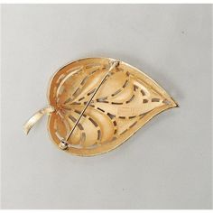 This is part of Chairish’s Costume Jewelry assortment.  1960s goldtone leaf with pave faux-citrine & clear rhinestone sections brooch with security clasp. Marked crown "Trifari." Measures: 2 5/8 inches long by 1 3/4 inches wide. Condition: Very good; small wear spot to back of the stem.  Please reference the measurements noted in the description above for the best approximate dimensions. Please reach out to the seller under "Ask the Seller" for specific questions regarding the measurements. Gold Brooches With 17 Jewels For Evening, Mid-century Gold Brooch Jewelry, Vintage Gold Leaf Jewelry, Vintage Gold Leaf-shaped Jewelry, Crown Trifari, Leaf Brooch, Modern Branding, Clear Rhinestones, Vintage 1960s