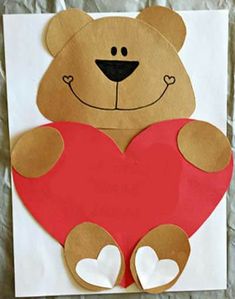 a paper cut out of a teddy bear holding a heart on a piece of white paper