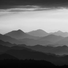 black and white photograph of mountains with dark clouds