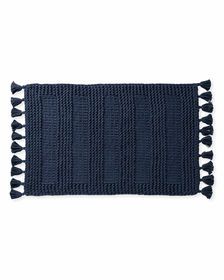 a blue rug with black tassels on the bottom and white trim around it