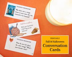 three cards with words on them sitting next to a candle and some other paper items