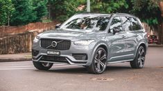 a silver volvo suv is driving down the street