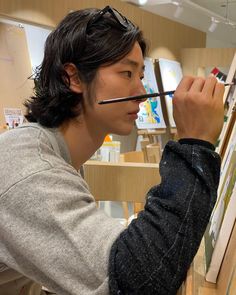 a young man is painting on an easel