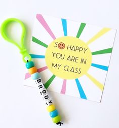 a happy birthday card with a name tag attached to it next to a pair of scissors