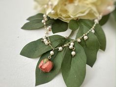 Indulge in the timeless elegance of our Pearl Rose Necklace. This exquisite piece showcases the perfect harmony of two natural wonders - freshwater pearls and real roses. Crafted with love and precision, the main material - freshwater pearls, symbolize purity, grace, and beauty. Each pearl used in this necklace is carefully selected for its exceptional luster and natural glow, making it a true treasure to behold. Complementing the pearls, we incorporate real roses into the design, creating a cap Elegant Pearl Necklaces With Flower Charm, Elegant Pearl Necklace With Flower Charm, Elegant Rose Gold Birth Flower Necklace, Elegant Rose Gold Flower Necklace With Birth Flower, Elegant Rose-colored Jewelry With Pressed Flowers, Elegant Rose Jewelry With Pressed Flowers, Elegant Flower Necklace With Pearl Charm, Elegant Flower Pendant Necklace With Pressed Flowers, Elegant Pearl Necklace With Flower Charm For Gift