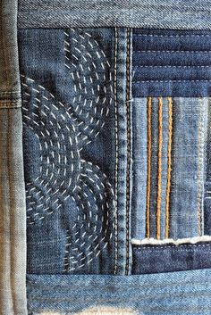 the back side of an old pair of jeans with stitchs and holes in it