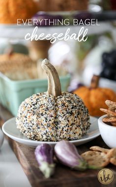 a white plate topped with a mini pumpkin covered in sprinkles next to crackers