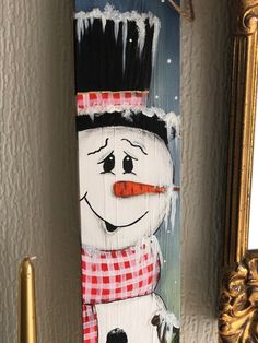 a painting of a snowman is hanging on the wall