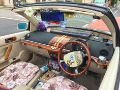 the interior of a car with an open trunk and floral seat covers on it's dashboard