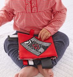 a small child is sitting on the bed with a book in his lap and holding it