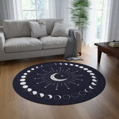 a living room with a couch, window and rug that has phases of the moon on it