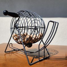 a metal object with some food inside of it on a wooden table next to a white wall