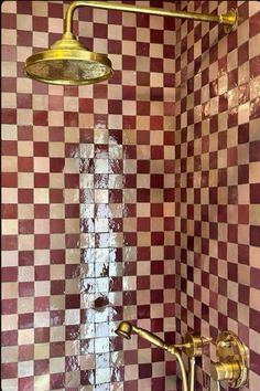 a shower head and faucet in a bathroom with checkered tile on the walls