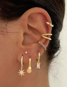 a close up of a person's ear with three different types of earrings on it