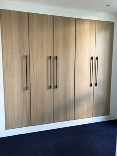 an empty room with wooden cabinets and blue carpet