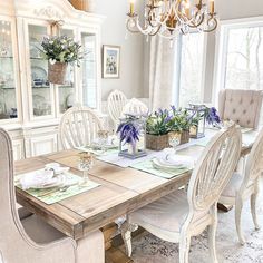 the dining room table is set with white chairs