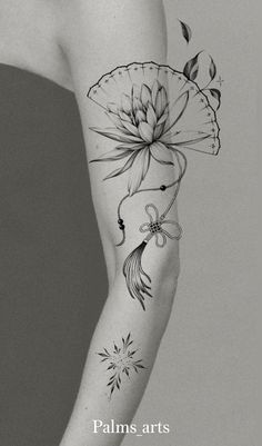 a black and white photo of a woman's arm with flowers, butterflies and leaves on it