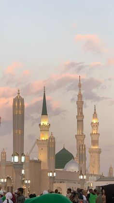 a group of people standing around in front of a building with many spires and lights