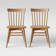 two wooden chairs sitting next to each other