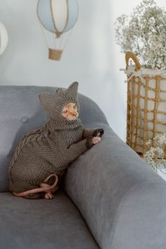 a stuffed animal sitting on top of a gray couch