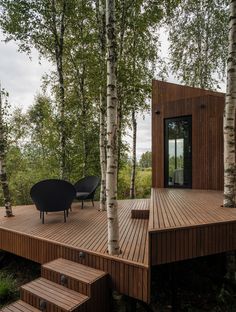 a wooden deck surrounded by trees and stairs