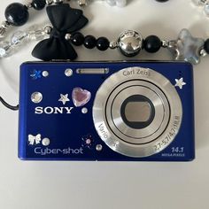 a blue camera sitting on top of a necklace