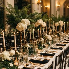 a long table is set with white flowers and greenery for an elegant wedding reception