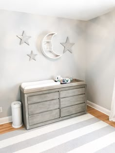 a baby's room with a dresser, crib and stars on the wall